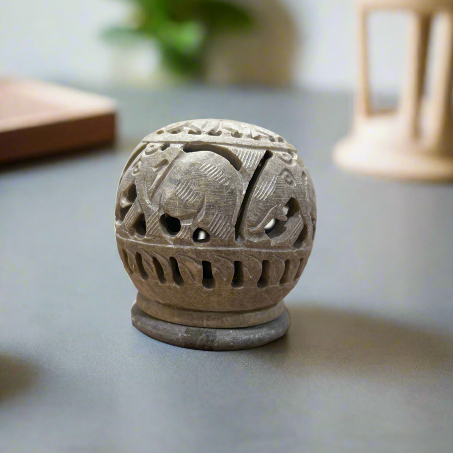 Ceramic incense holder with elephant design on a gray surface