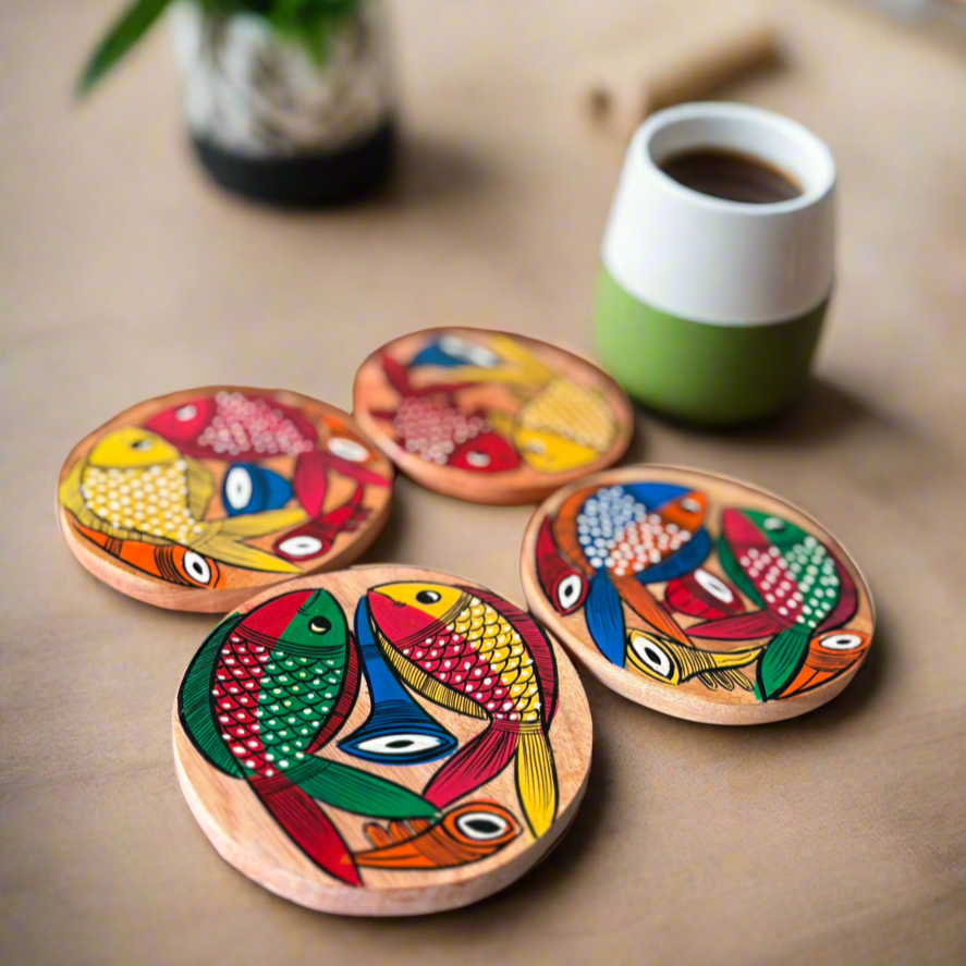 Set of colorful wooden coasters with fish design on a table with a cup of coffee.