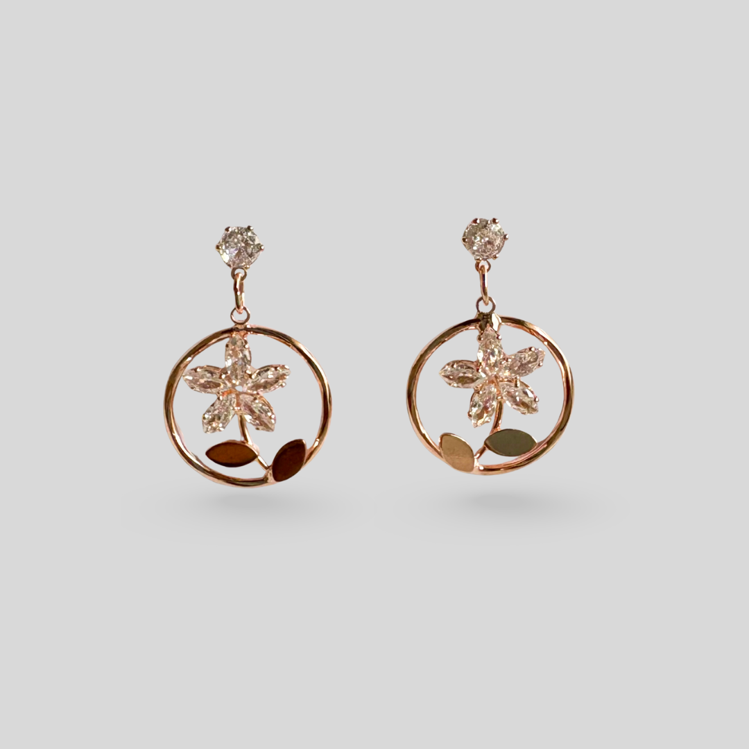 Rose gold floral earrings on a light gray background