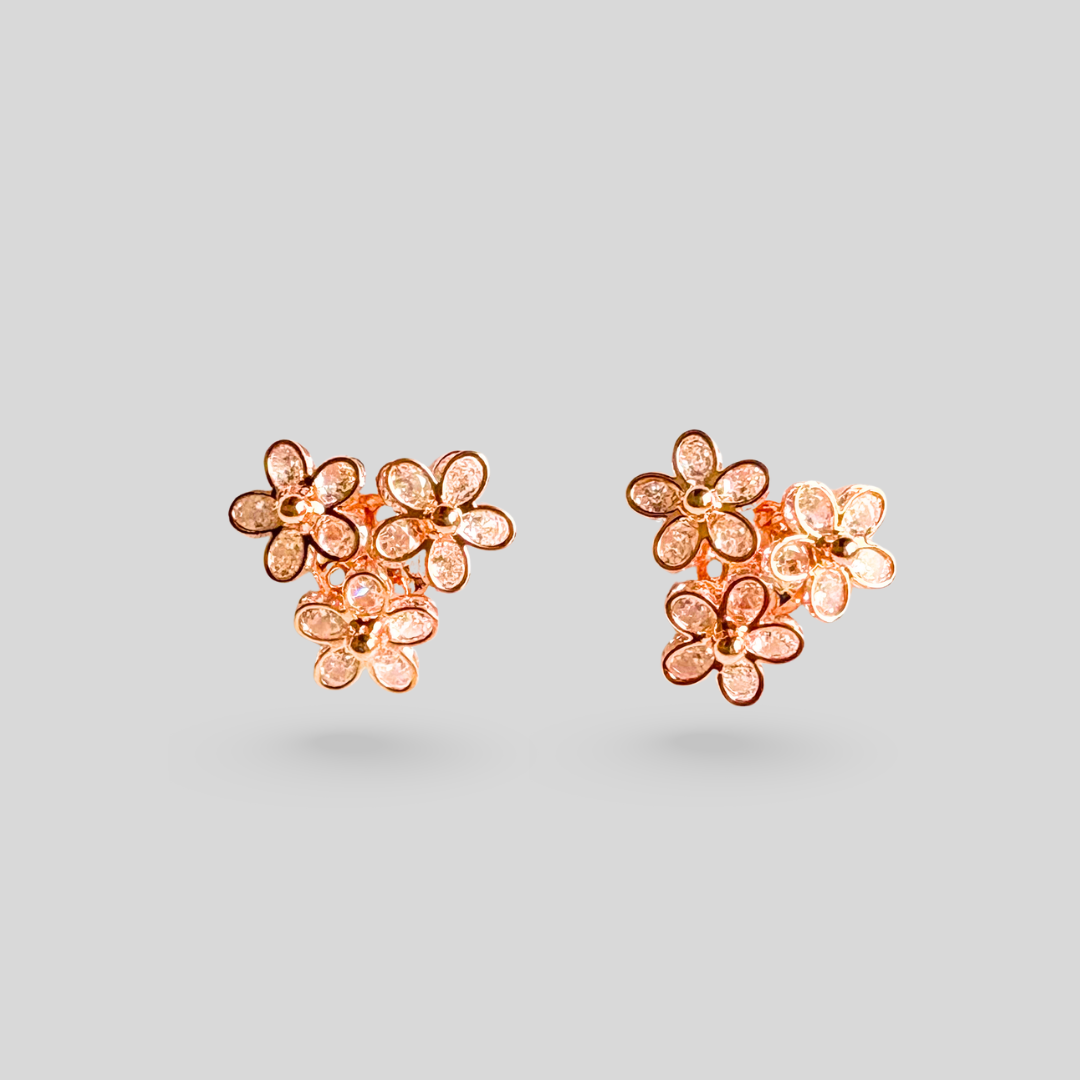Rose gold floral earrings on a light gray background