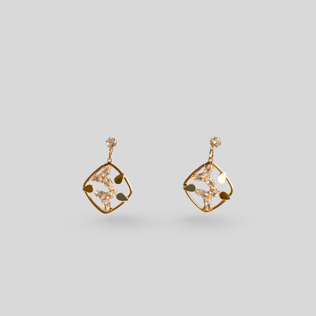 Pair of gold earrings on a light gray background