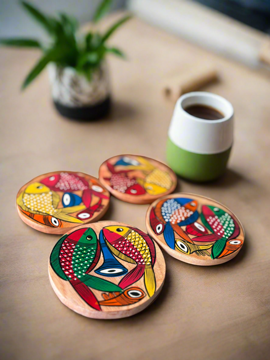 Set of colorful wooden coasters with fish design on a table with a cup of coffee.