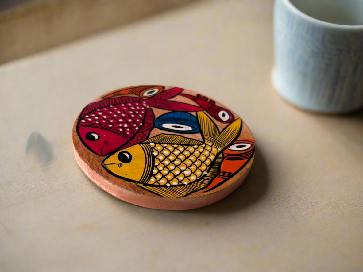 Wooden coaster with fish design on a table next to a mug