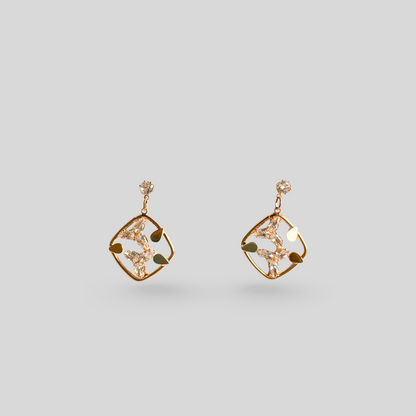 Pair of gold earrings on a light gray background